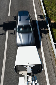 From above of road security camera recording speed of automobile driving along highway on sunny day