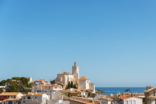 Picturesque view of old small Cadaques town located on bay of Mediterranean sea in sunny summer day with calm blue water
