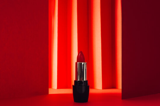 Red lipstick in elegant shiny tubes placed on red background