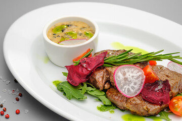 Grilled maso with vegetables and rosemary on a white plate.