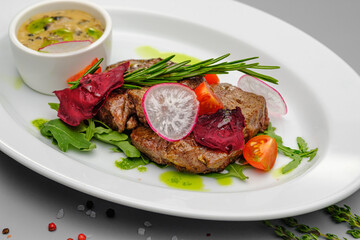 Grilled maso with vegetables and rosemary on a white plate.