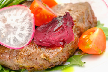 Grilled maso with vegetables and rosemary on a white plate.