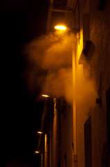 Fototapeta na wymiar Illuminated street lights in the fog at night. Sabiñanigo. Huesca. Aragon. Spain.