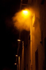 Illuminated street lights in the fog at night. Sabiñanigo. Huesca. Aragon. Spain.