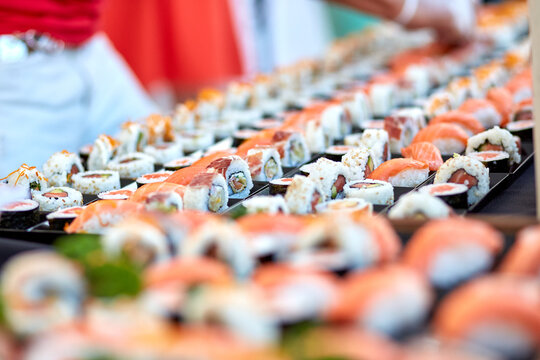 High angle of assorted palatable sushi and rolls placed in plastic containers in store