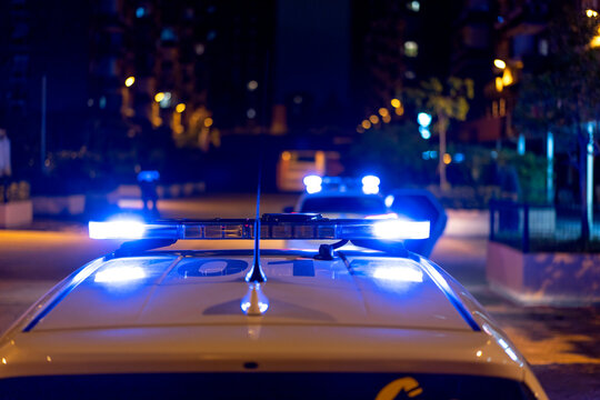 Contemporary police vehicle with siren light on the road on background of amazing night cityscape