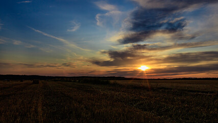 Fototapeta na wymiar Sunset over agricultural field against cloudy sky in Möckmühl, Germany