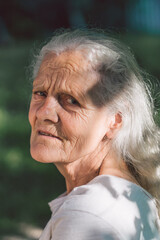 Portrait of a gray-haired adult grandmother against the background of nature