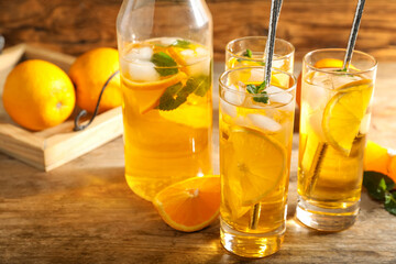 Delicious refreshing drink with orange slices on wooden table