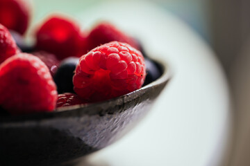 Bowl with yummy ripe blueberries and raspberries
