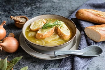 Classic French onion soup in a ceramic bowl, topped with baguette slices and shredded cheese