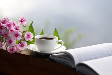 cup of coffee, book and flowers on the table