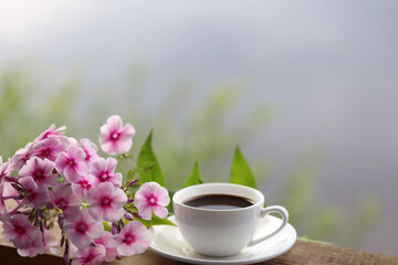 cup of coffee, book and flowers on the table