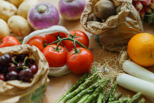 Top view of assorted fresh vegetables and ripe fruits arranged on wooden table