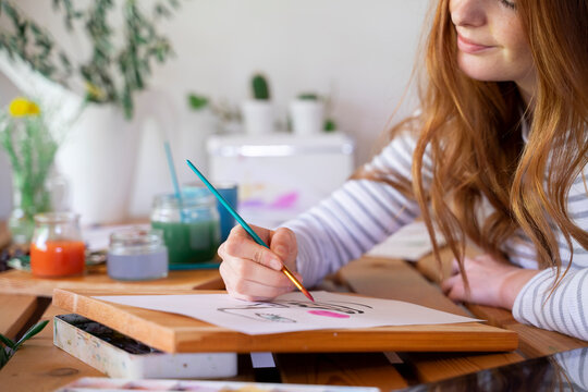 Cropped Image Of Young Woman Painting On Paper At Home