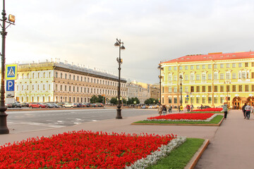Fototapeta premium St Petersburg. Yellow house and flowerbed with red flowers. Ancient Street lamp. 