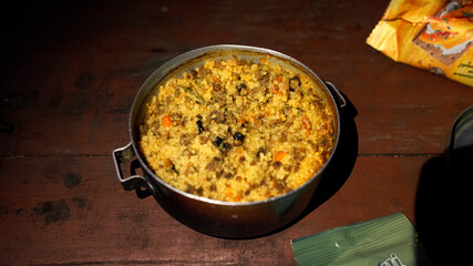 Moroccan-style couscous with beef and dried fruit in an old pot. Camping cookery.