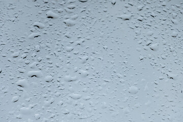 texture of bokeh drops on glass in front of urban park landscape