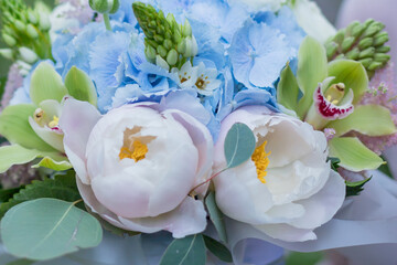 Flower arrangement in a blue hat box was created by a florist for a wedding gift. Flower bouquet of...