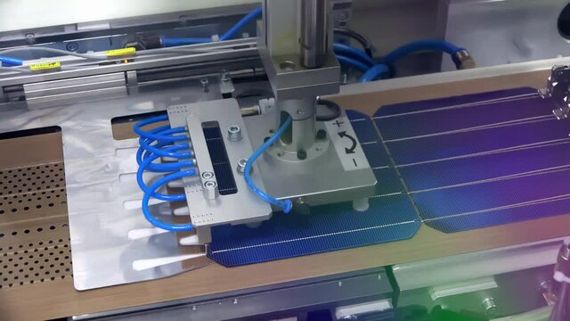 Automated Solar Cell Stringer Machine Feeding Copper Ribbons and Performing Tabbing on Silicon Photovoltaic Cells in PV Module Production Line