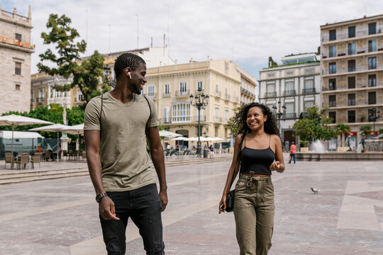 Fototapeta Happy man and woman walking on city street
