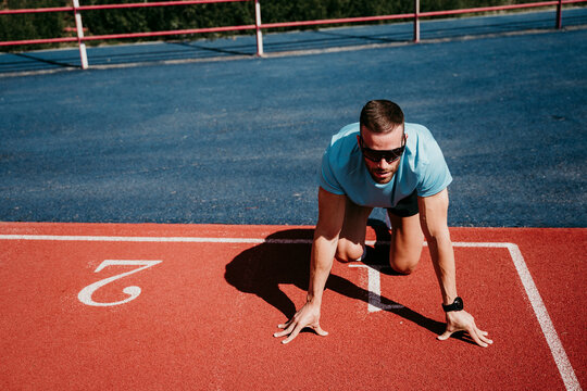 Male athlete in starting position on tartan track