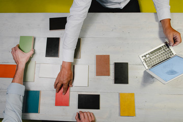Hands of architects choosing colour samples in office