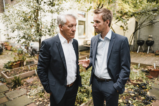 Two Businessmen Standing Office Backyard, Discussing