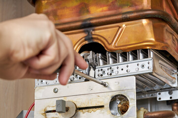 service technician repairing gas water heater indoors. water heater maintenance. diy concept