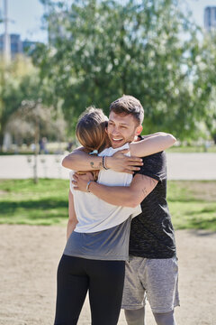 Embracing couple before work out in park