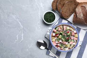 Delicious cold okroshka with kvass served on grey table, flat lay and space for text. Traditional Russian summer soup
