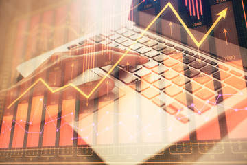 Double exposure of woman hands typing on computer and forex chart hologram drawing. Stock market...