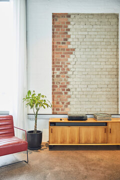 Interior Of A Loft Flat With Brick Wall And Chest Of Drawers