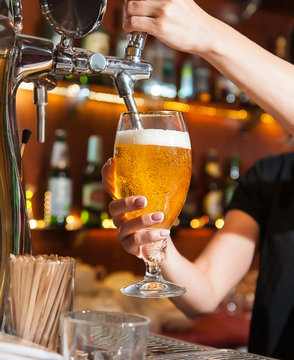 Beer Pouring From The Tap Into The Glass