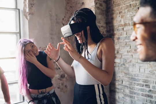 Happy creative team using Vr goggles in loft office