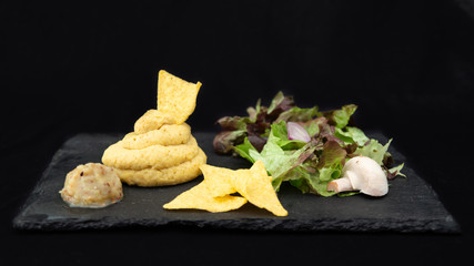 
Artisanal hummus and homemade eggplant caviar, triangular corn chips, and fresh mushrooms, shallot and salad, on a slate