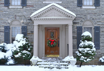 front door with colorful wreath in winter scene