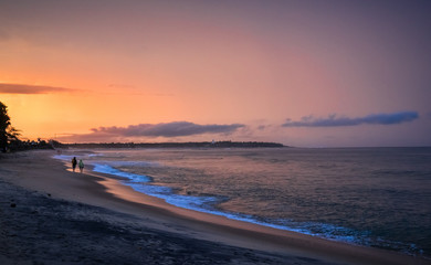 People walking on the beach. Beautiful sunset over the sea, orange And purple sky. Arugam bay, Ceylon. Panoramic format