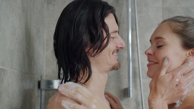 Girlfriend and boyfriend beautiful young people are wahsing in shower kissing and hugging expressing love. Affection, relationship and marriage concept.