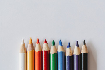 Rainbow of coloring pencils on plain white background