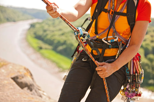 close up of woman rappelling of cliff in south Wales