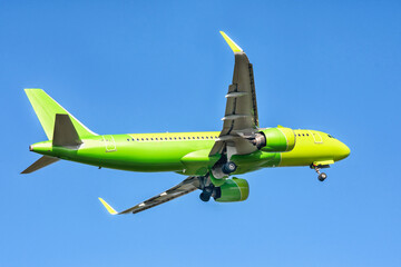A big yellow jet flying on background of blue sky.