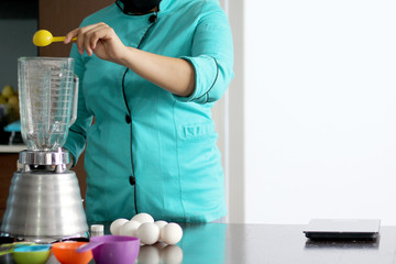 woman chef hands preparing whipping flour for cake with kitchen utensils