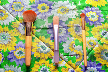 makeup brushes on colourful floral background