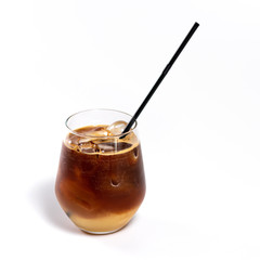 Iced coffee in a tall glass with cream, ice cubes. Cold summer drink whit pipes on white background