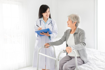 Obraz premium walk training and rehabilitation process, old asian stroke patient learning to use walker with female asian doctor, elderly healthcare promotion, doctor order and explain, happiness hospital