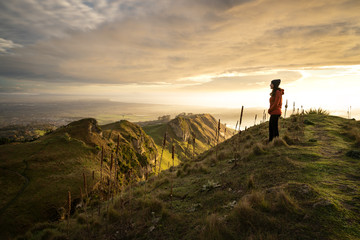 Young woman staring at the beautiful landscape from the top of a mountain. Te Mata Peak, New Zealand