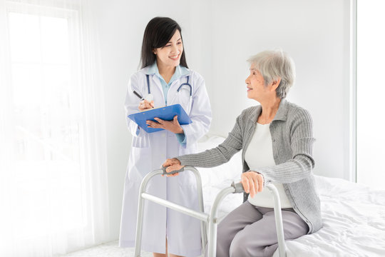 walk training and rehabilitation process, old asian stroke patient learning to use walker with female asian doctor, elderly healthcare promotion, doctor order and explain, happiness hospital
