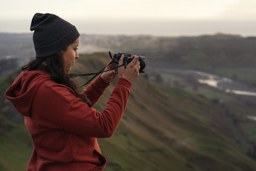 Woman taking a photo with a camera in the mountains
