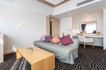 Fabric sofa and a working corner in the living room of a large apartment at the condominium